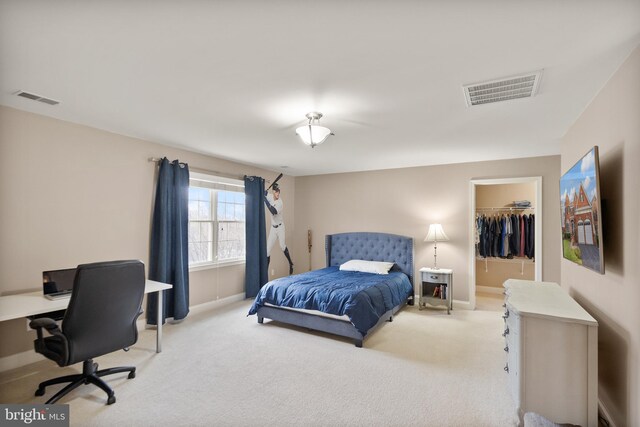 carpeted bedroom with a spacious closet and a closet