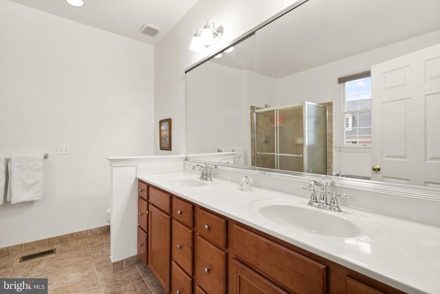 bathroom with a shower with door, vanity, and toilet