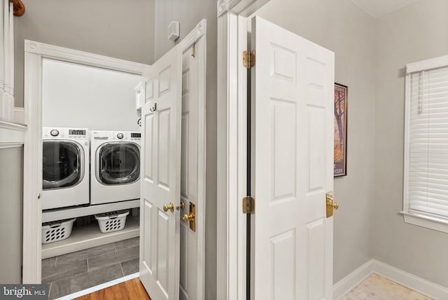 laundry area featuring wood-type flooring and separate washer and dryer