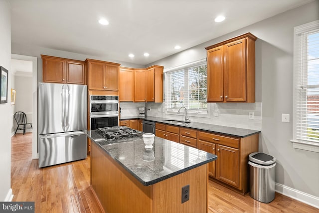 kitchen featuring light hardwood / wood-style flooring, sink, a kitchen island, and black appliances