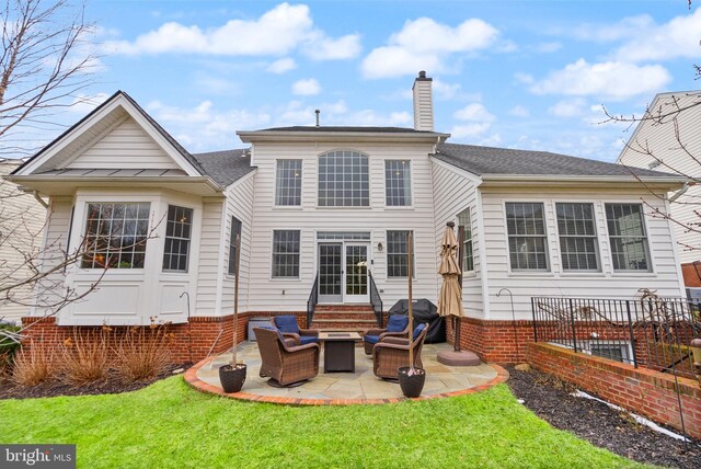 rear view of property featuring an outdoor living space, a patio area, and a lawn