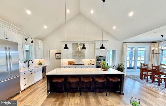 kitchen featuring appliances with stainless steel finishes, sink, pendant lighting, and a spacious island