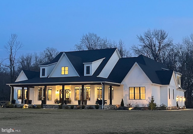 modern farmhouse with covered porch and a lawn