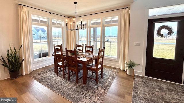 dining space featuring hardwood / wood-style flooring and a chandelier