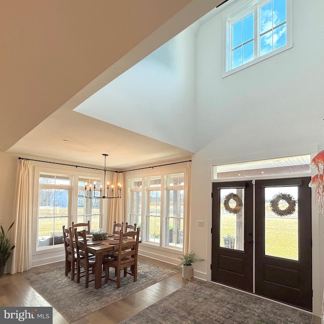 foyer entrance featuring french doors, dark hardwood / wood-style flooring, and a notable chandelier