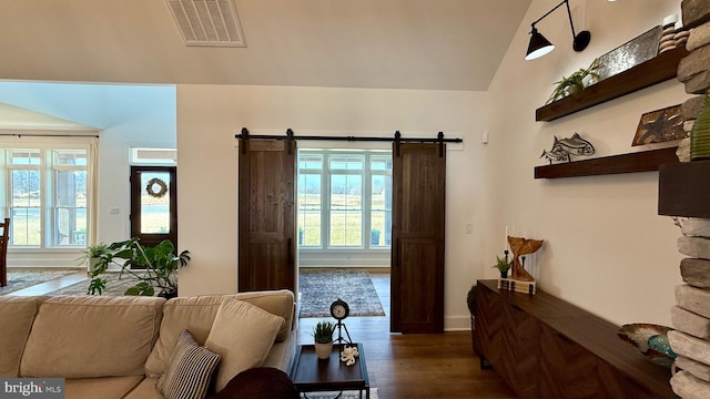 living room featuring a barn door and dark hardwood / wood-style flooring