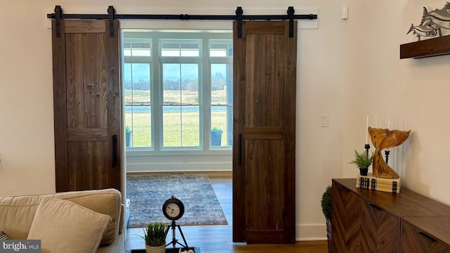 entryway with a barn door and hardwood / wood-style floors