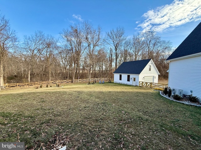 view of yard with a garage and an outbuilding