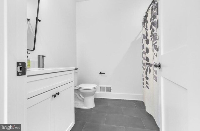 bathroom featuring vanity, toilet, and tile patterned flooring