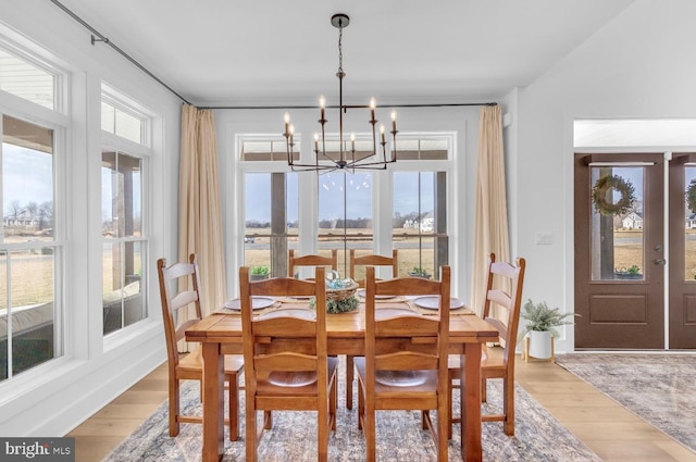 dining space featuring hardwood / wood-style flooring, plenty of natural light, and a chandelier