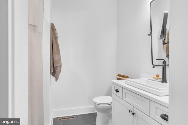 bathroom with vanity, toilet, and tile patterned flooring