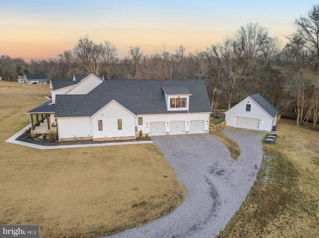 view of front of property with a garage, covered porch, and a lawn