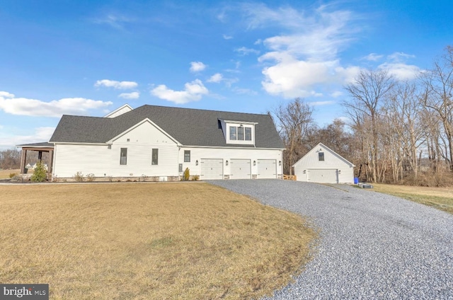 view of front facade with a garage, an outdoor structure, and a front yard