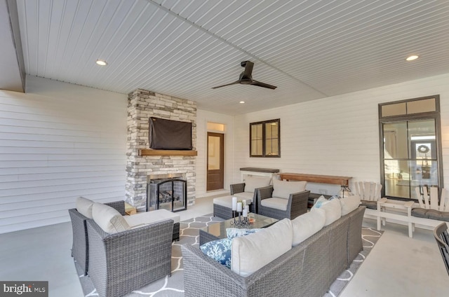 view of patio / terrace featuring ceiling fan and an outdoor living space with a fireplace