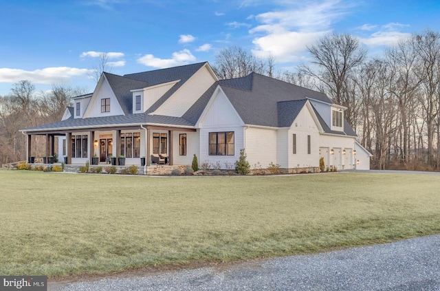 view of front of house with a garage, a front yard, and covered porch