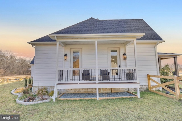 view of front of property featuring covered porch and a lawn