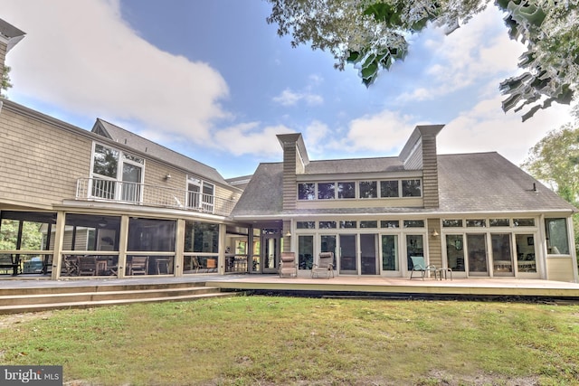 rear view of property with a yard and a sunroom