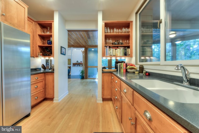 kitchen with stainless steel fridge, sink, and light wood-type flooring