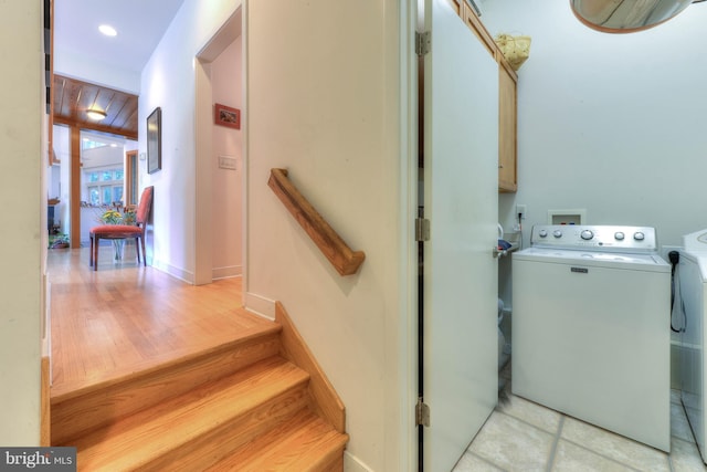 washroom with cabinets and washing machine and clothes dryer