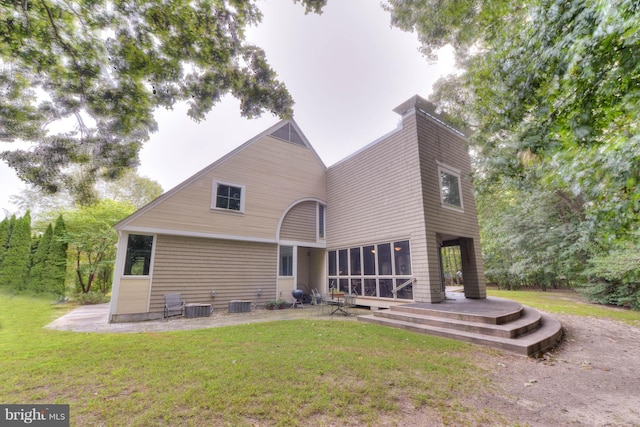 back of property featuring a yard and a sunroom