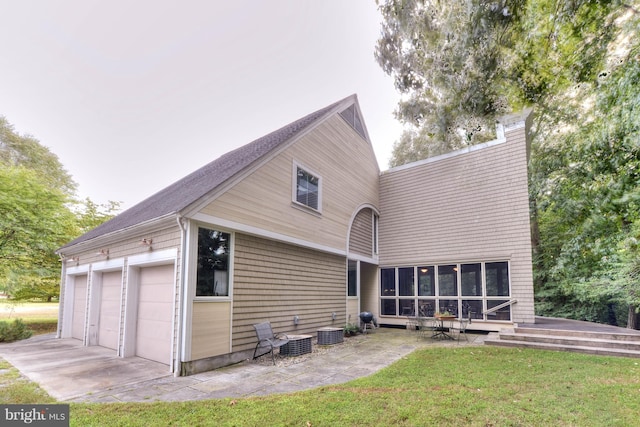 back of house featuring a patio area and a lawn