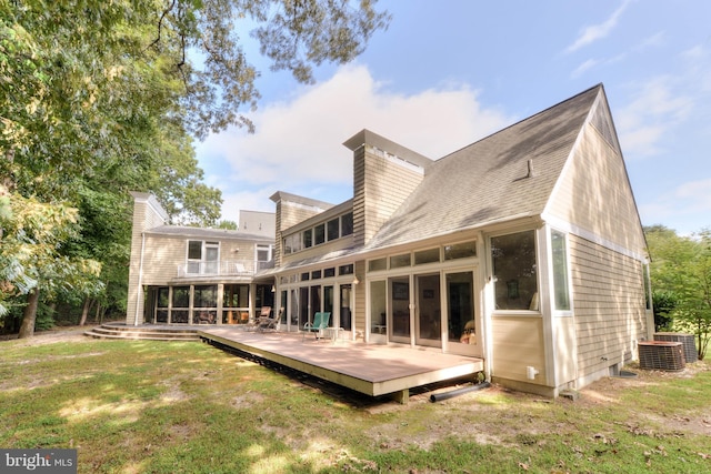 rear view of house with a wooden deck, central AC, and a lawn