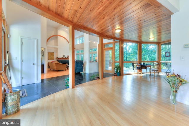 interior space featuring wood ceiling, hardwood / wood-style flooring, floor to ceiling windows, and a high ceiling