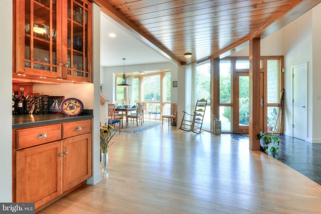 interior space featuring pendant lighting, wood ceiling, and light hardwood / wood-style flooring