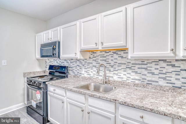 kitchen with sink, white cabinetry, black appliances, light hardwood / wood-style floors, and backsplash