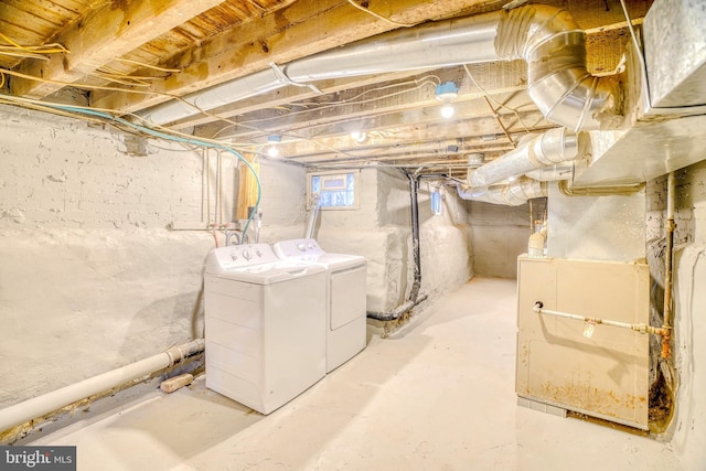 basement with heating unit and washing machine and clothes dryer