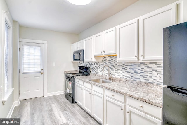 kitchen with decorative backsplash, sink, white cabinets, and black appliances