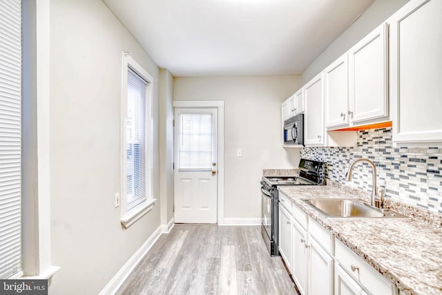 kitchen featuring white cabinetry, sink, decorative backsplash, and black appliances