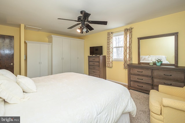 bedroom featuring attic access, carpet, baseboards, and a ceiling fan