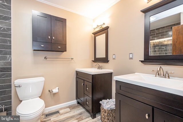 bathroom with toilet, two vanities, a sink, and visible vents