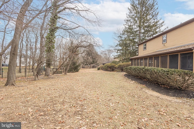 view of yard with a sunroom and fence