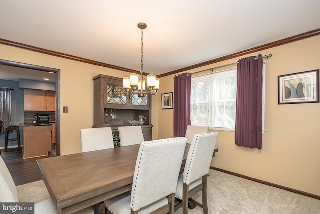 dining room with baseboards, an inviting chandelier, and crown molding