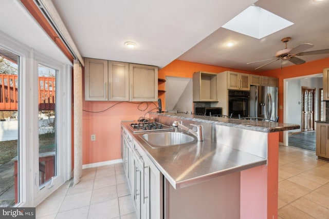 kitchen with a skylight, appliances with stainless steel finishes, open shelves, a sink, and light tile patterned flooring