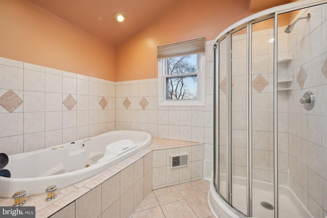 full bathroom featuring lofted ceiling, tile patterned flooring, a garden tub, visible vents, and a shower stall