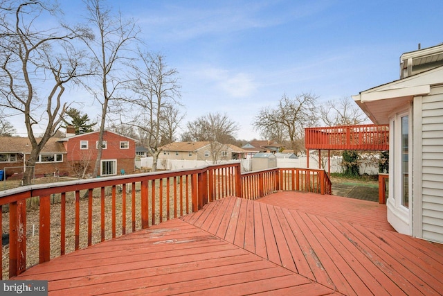 wooden terrace featuring a residential view and fence