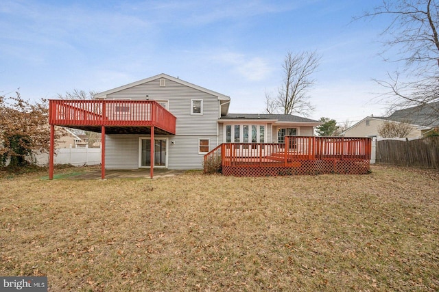 back of property with a yard, fence, and a deck