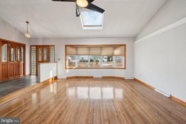 unfurnished living room with lofted ceiling with skylight, visible vents, and wood finished floors