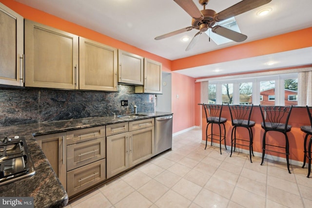 kitchen featuring dark stone counters, stainless steel dishwasher, a kitchen bar, and decorative backsplash