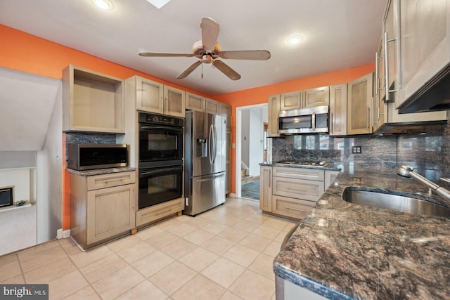 kitchen featuring ceiling fan, appliances with stainless steel finishes, a sink, and decorative backsplash