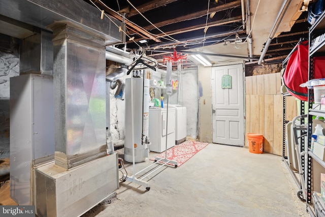 basement featuring heating unit, gas water heater, and washer and dryer