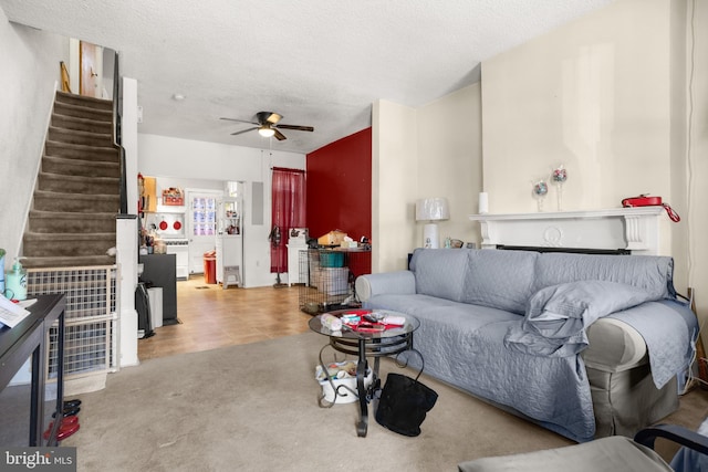 living room featuring light colored carpet, a textured ceiling, and ceiling fan