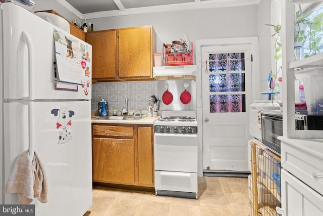 kitchen with sink, crown molding, light tile patterned floors, white appliances, and backsplash