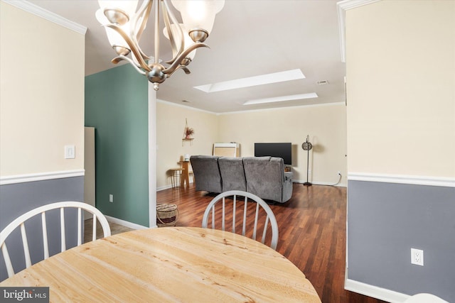 dining space with ornamental molding, dark hardwood / wood-style floors, a chandelier, and a skylight