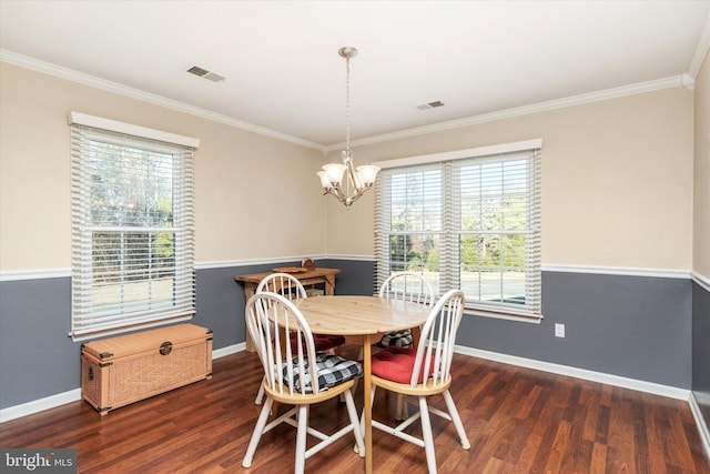 dining room featuring ornamental molding, dark wood-type flooring, and a chandelier