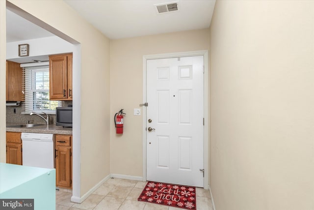 foyer entrance with light tile patterned flooring and sink