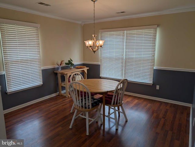 dining room featuring an inviting chandelier, ornamental molding, and dark hardwood / wood-style flooring